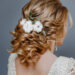 Rear view close-up of the finished wedding hairstyles in the form of winter bride with cotton flowers decoration
