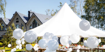 Wedding tent with large balls. Tables sets for wedding or another catered event dinner.